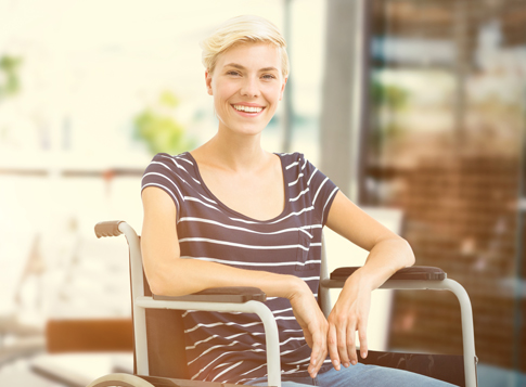 Femme souriante sur un fauteuil roulant